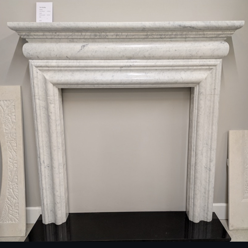 Bolection style handmade fireplace in Italian Carrara Bianco marble