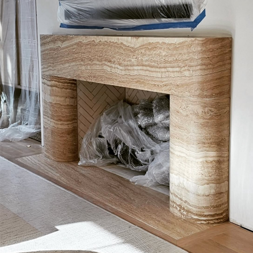 Vein cut travertine fireplace mantel with curving legs into the firebox