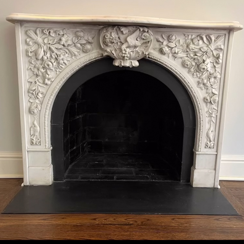 Antique marble fireplace mantel with floral carving detail